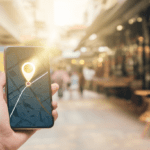 Smartfon z widoczną mapą i pinezką lokalizacji symbolizujący reklamę w Google Maps i koszty kliknięcia